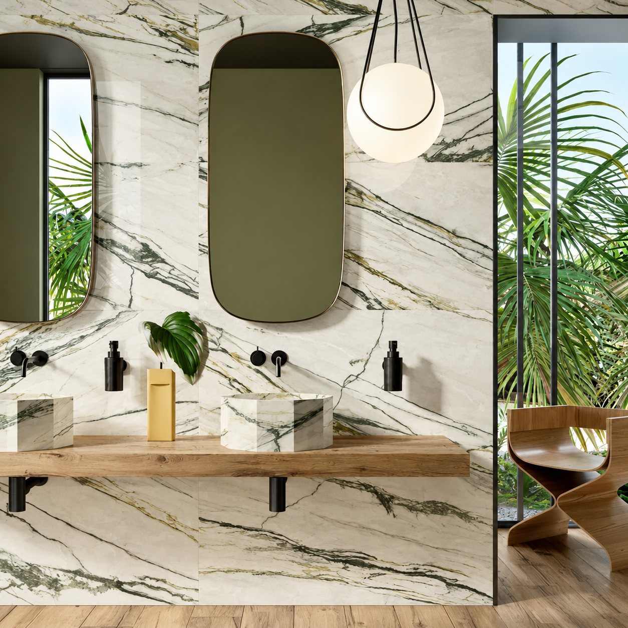Salle de bain moderne aux murs de marbre veiné de vert, avec deux vasques hexagonales sur un plan en bois, deux miroirs ovales et une suspension ronde, ouverte sur un jardin de palmiers.