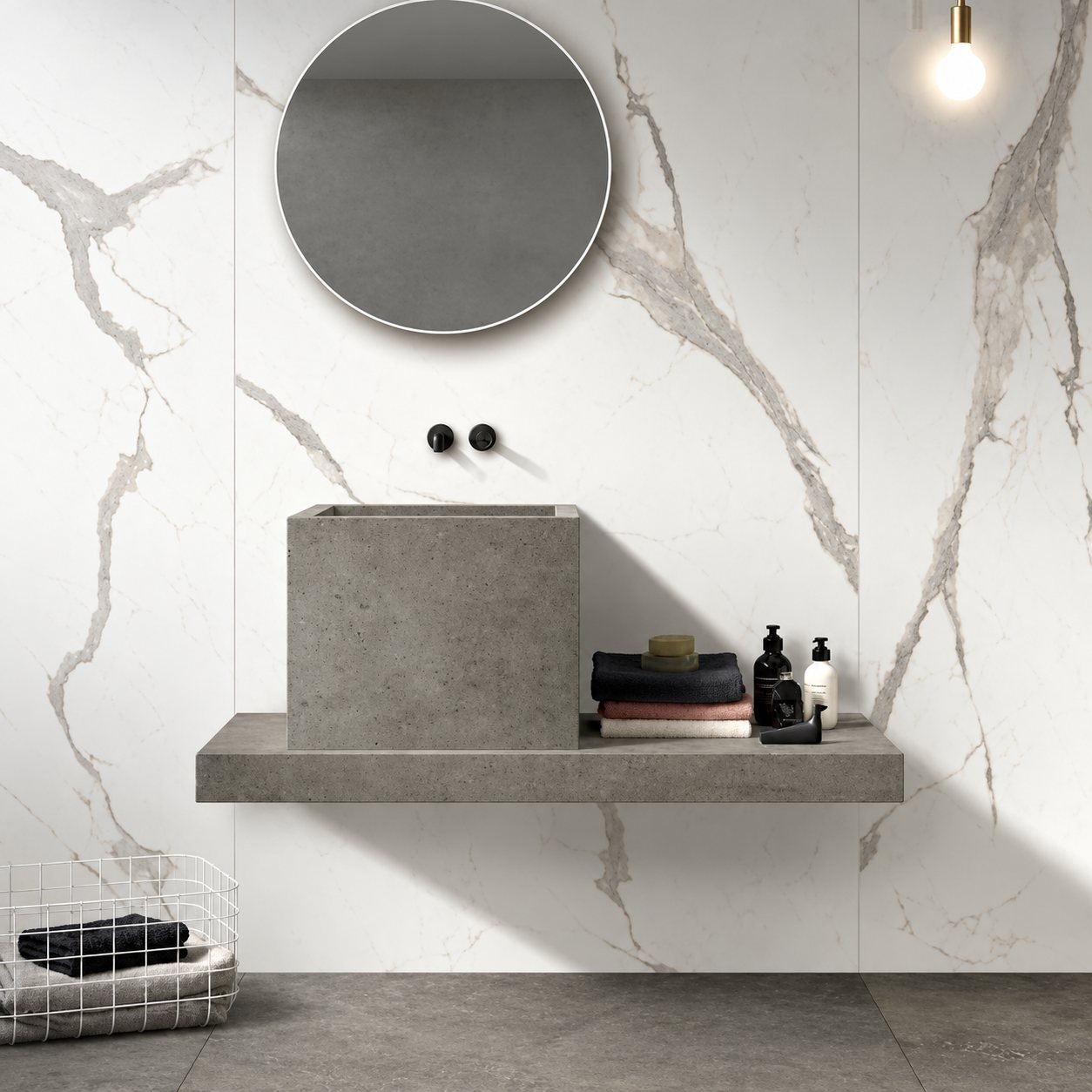 Salle de bains contemporaine avec une vasque carrée en béton gris posée sur une tablette, un miroir rond et des murs en grès cérame effet marbre blanc.