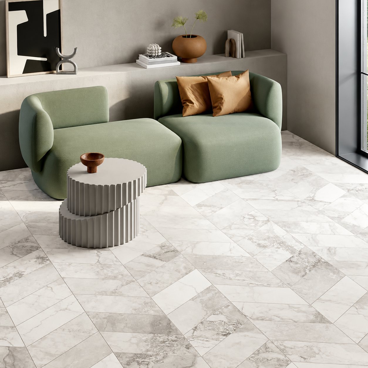 Un salon contemporain avec un canapé modulable vert sauge, des coussins caramel, une table basse cannelée et un sol en carrelage gris effet marbre posé en chevrons.