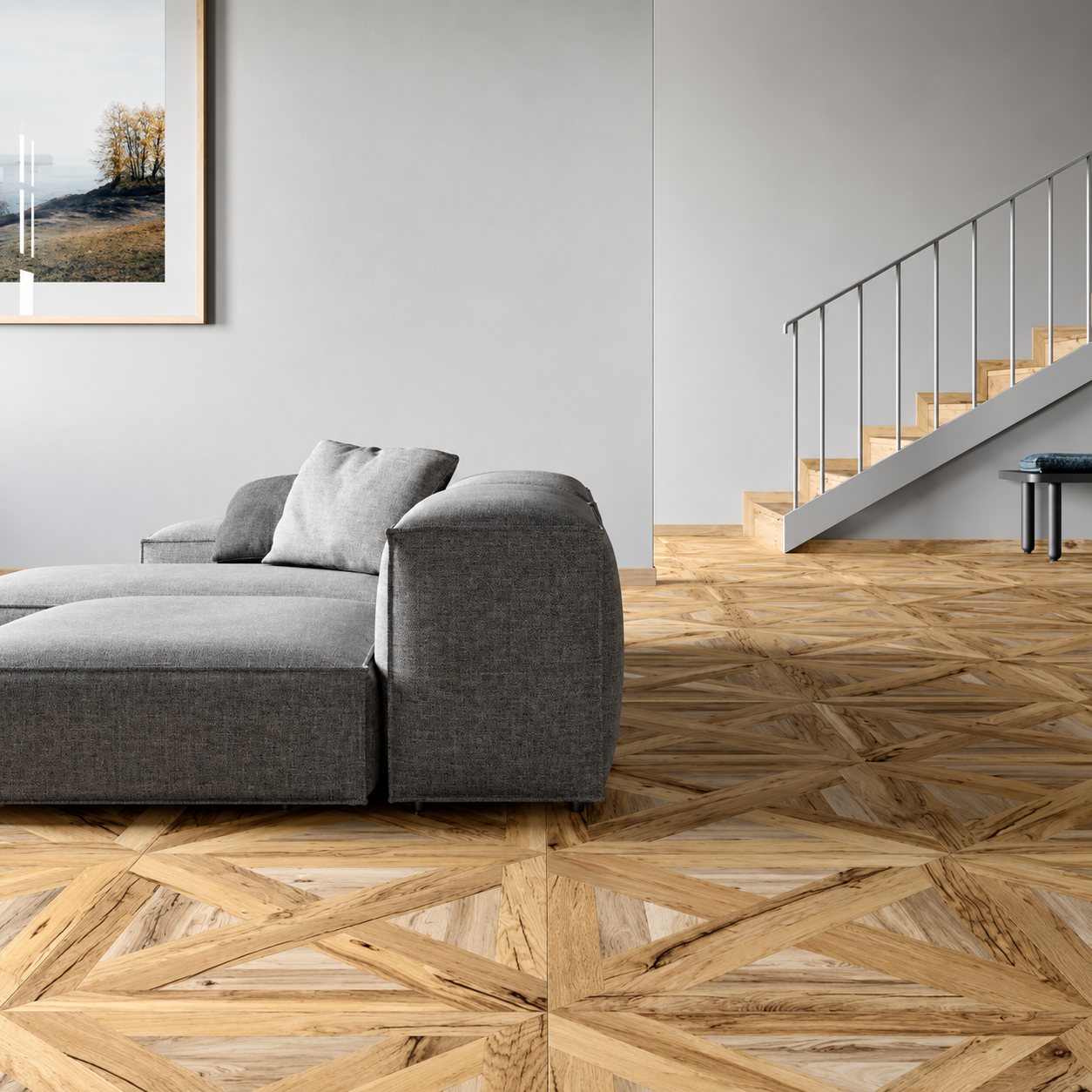 Un salon moderne aux murs gris avec un canapé d'angle gris foncé, un escalier en bois et un sol en parquet à motif géométrique.